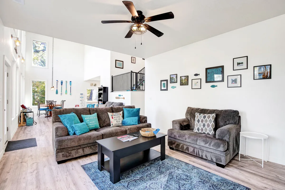 A cozy living area with comfortable sofas, a coffee table, wall art, and a ceiling fan, creating a relaxed and social atmosphere. The interior is a likely spot for an integrated communication panel.